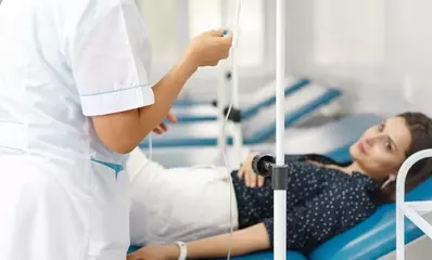 медсестра ставит женщине капельницу