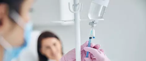 Медсестра готовит капельницу для пациентки
